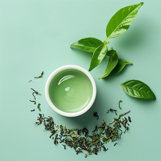 A top-view image featuring a bowl of green tea with fresh tea leaves and loose tea leaves arranged artfully on a light green background. The composition highlights the natural and refreshing essence of green tea.